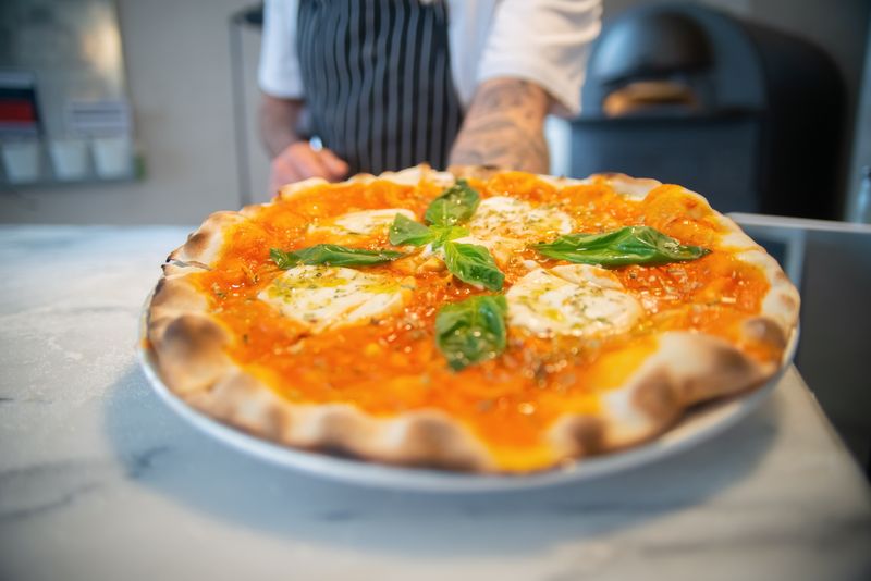 Margherita round table pizza with fresh basil and mozzarella